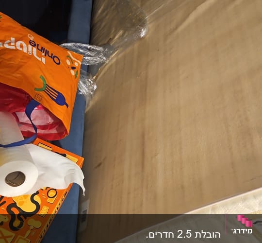 מזרן עטוף בניילון על ספה כחולה עם שקיות